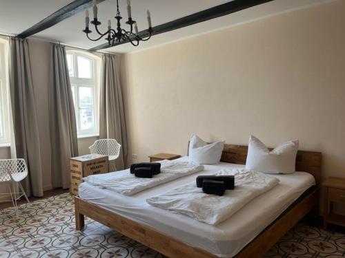 a bedroom with a large bed with white sheets and pillows at Ferienwohnungen Hafenkabinett, 25529 in Weener