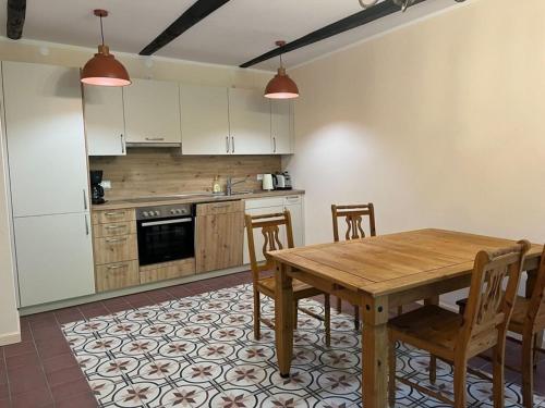 a kitchen with a wooden table and chairs at Ferienwohnungen Hafenkabinett, 25529 in Weener