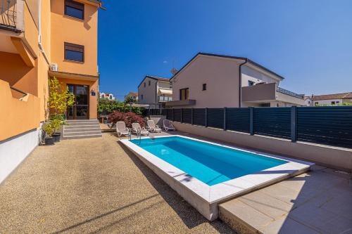 a swimming pool on the side of a house at Bellona in Malinska