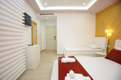 ein Hotelzimmer mit zwei Betten und einer Couch in der Unterkunft Rio Boutique Hotel Vlore in Vlorë