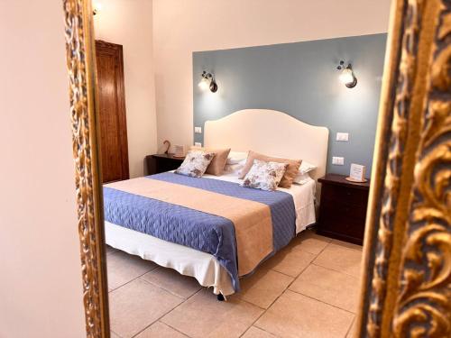 a bedroom with a large bed and a mirror at Villa B&B Antiche Macine del Salento - nel cuore del Salento in Salve