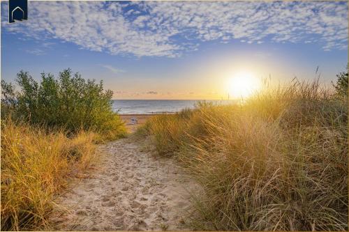 a path to the beach with the sun rising over the ocean at FeWo 11 "Seelenwind" in Benz