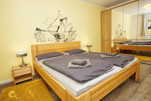 una camera da letto con un letto grande in una stanza di Residenz Waldidyll FeWo Kleiner Stubber - ruhige Lage, mit Sauna- und Schwimmbadnutzung im AHOI Sellin a Ostseebad Sellin