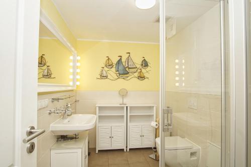 un bagno con lavandino e doccia di Residenz Waldidyll FeWo Kleiner Stubber - ruhige Lage, mit Sauna- und Schwimmbadnutzung im AHOI Sellin a Ostseebad Sellin