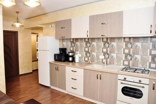 eine Küche mit einer Spüle und einem weißen Kühlschrank in der Unterkunft Apartment Ovidius - by the beach in Constanţa