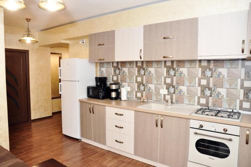 a kitchen with a sink and a white refrigerator at Apartment Ovidius - by the beach in Constanţa