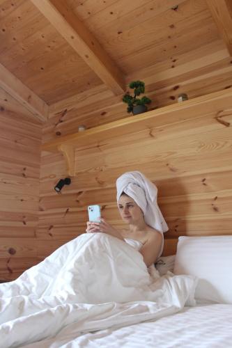 a woman laying in bed holding a cell phone at GomuL in Vorokhta