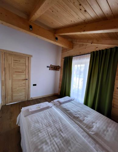a bedroom with a large bed with a window at GomuL in Vorokhta
