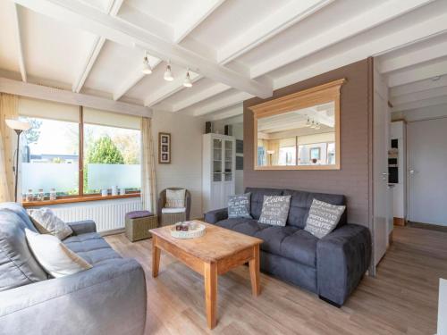 a living room with a couch and a table at Holiday Home Sint Maartenszee near Beach in Sint Maartensvlotbrug