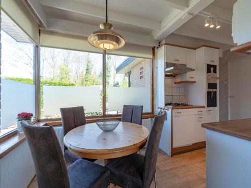 a kitchen and dining room with a wooden table and chairs at Holiday Home Sint Maartenszee near Beach in Sint Maartensvlotbrug