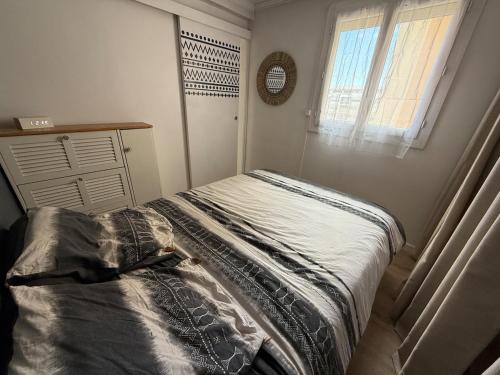 un lit dans une chambre avec une fenêtre et un lit sidx sidx sidx dans l'établissement Appartement Cosy à Carnon, à Mauguio