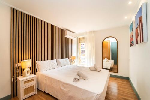 a bedroom with a large white bed in a room at Stylish Seaview Apartment with Pool Access in Benidorm