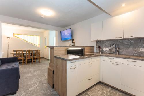 a kitchen with white cabinets and a dining room at Sonnige Ruhe in Embach