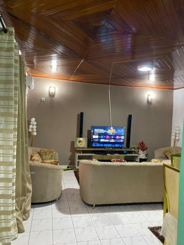 a living room with couches and a flat screen tv at FABI House in Yaoundé