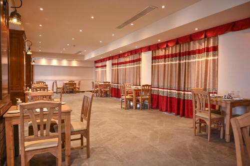 a restaurant with wooden tables and chairs and red curtains at Riviera Aqua Park Resort in Hurghada