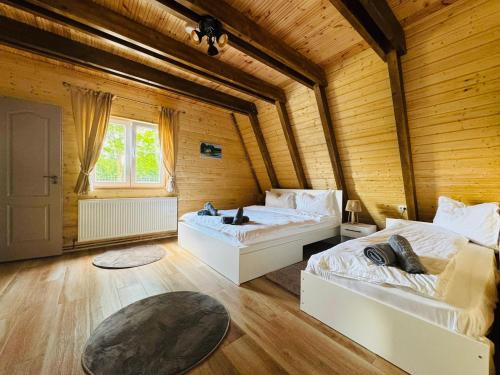 a bedroom with two beds in a wooden room at Cabana Twins A-Frame 1 in Sibiu