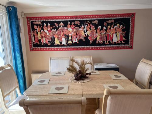 a dining room table with a painting on the wall at Ceylon HomeStay in Knightswood