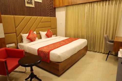 a hotel room with a bed and a red chair at hotel pride & restaurant in Dabok
