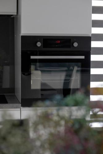 a black oven with the door open in a kitchen at Paraiso Nadmorskie Apartamenty z Basenem i Parkingiem by Noclegi Renters in Łukęcin