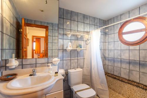 a bathroom with a sink and a toilet and a mirror at Breathtaking Beachfront Villa in Xeraco in Xeraco