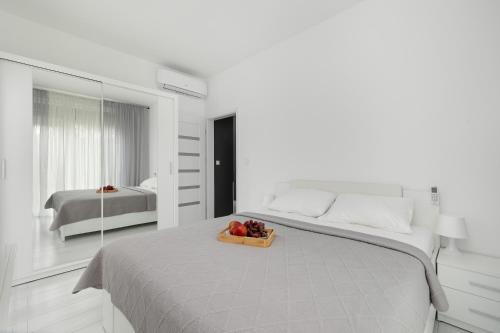 a bedroom with a bed with a bowl of fruit on it at Paraiso Nadmorskie Apartamenty z Basenem i Parkingiem by Noclegi Renters in Łukęcin