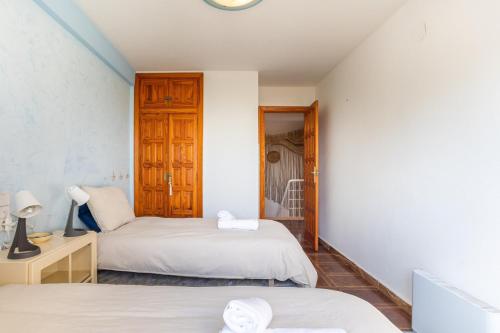 a bedroom with two beds and a desk with a mirror at Breathtaking Beachfront Villa in Xeraco in Xeraco
