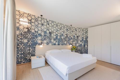a bedroom with a white bed and a blue and white wall at Hotel Baia Imperiale in Campo nell'Elba