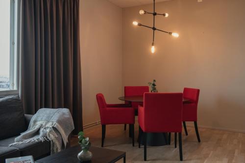 a dining room with a table and red chairs at Home Hotel Odin in Gothenburg