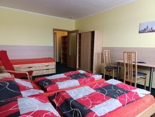 two beds in a room with a table and chairs at Pavilon v ráji in Žďár