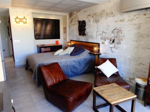 - une chambre avec un lit et un fauteuil en cuir dans l'établissement Appartement CAP FACTORY Héliopolis K1 - Luxe 2 personnes, au Cap d'Agde