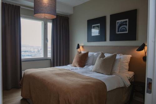 a bedroom with a large bed with a large window at Home Hotel Odin in Gothenburg