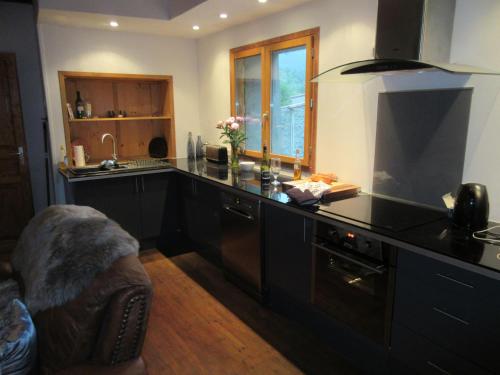 - une cuisine avec un plan de travail noir et un évier dans l'établissement Maison Bleu, à Puilaurens