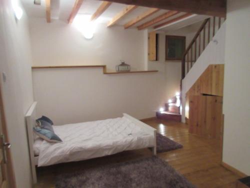 une chambre avec un lit dans une pièce avec un escalier dans l'établissement Maison Bleu, à Puilaurens