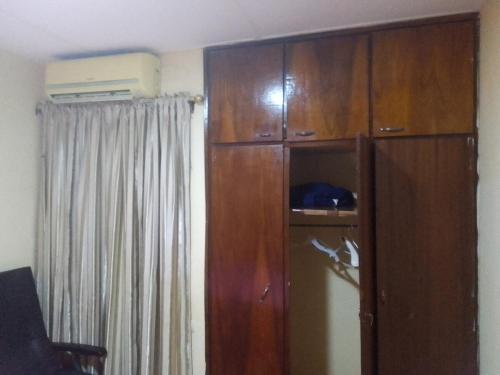 a large wooden cabinet in a room with a curtain at Furnished two-bedroom villa in Ouagadougou