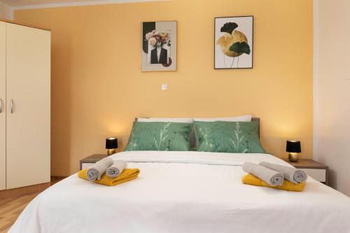 a bedroom with a white bed with towels on it at Apartments ADELA in Polje