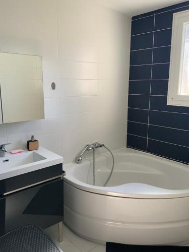 une salle de bain avec une baignoire et un lavabo dans l'établissement Maison spacieuse très calme, Albi centre, à Albi