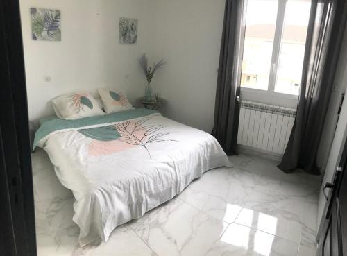 une chambre avec un lit avec des draps blancs et une fenêtre dans l'établissement Maison spacieuse très calme, Albi centre, à Albi