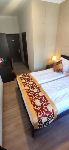 a bedroom with a bed with a brown and white blanket at Sun-House Pension&Restaurant -ParkingFree- in Prague
