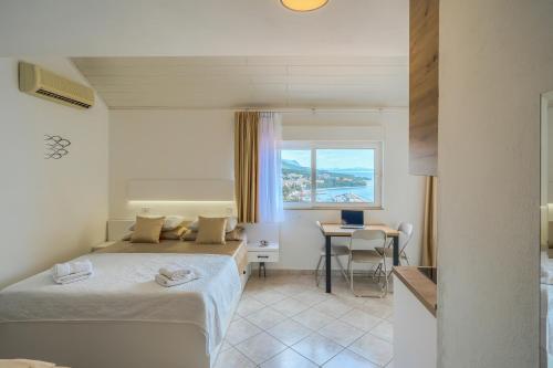 a room with two beds and a table and a window at Villa LeMar in Baška Voda