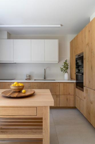 a kitchen with a wooden table with a bowl of fruit on it at Villa Calma a Beachfront Luxury Retreat in Porto Heli