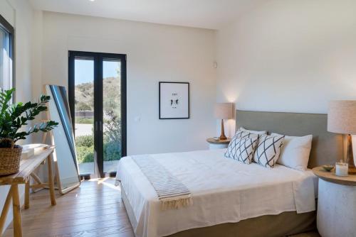 a bedroom with a bed and a large window at Villa Calma a Beachfront Luxury Retreat in Porto Heli