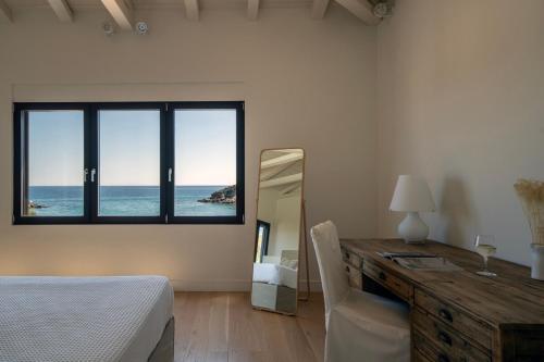 a bedroom with a desk and a bed and a mirror at Villa Calma a Beachfront Luxury Retreat in Porto Heli