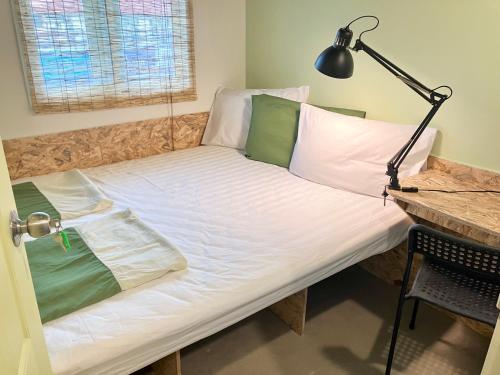 a bed in a room with a desk and a lamp at 326 Podtel at The Breakie Bar in Bangkok