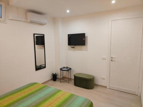 a bedroom with a bed and a tv on the wall at Suite12 in Marsala