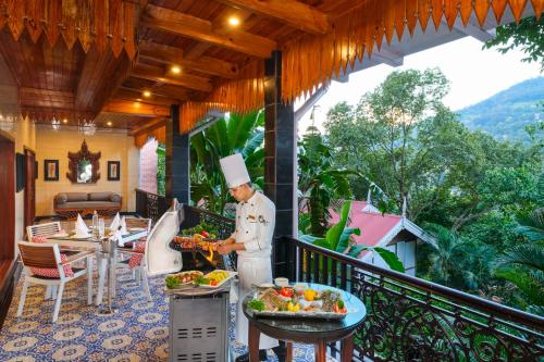 a chef preparing food on the balcony of a resort at Mayfair Spa Resort & Casino in Gangtok