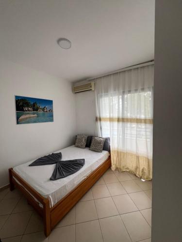 a bedroom with a bed and a window at Hotel PEJA in Velipojë