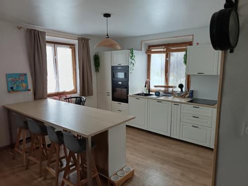 une cuisine avec des armoires blanches et une table en bois dans l'établissement Kids-Friendly Family Home, à École