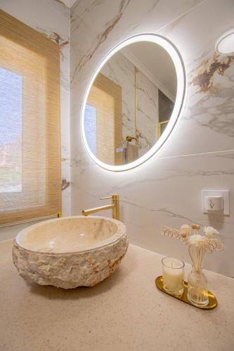 a bathroom with a large stone sink and a mirror at Apartment Bela Vista in Estômbar