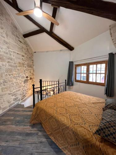 une chambre avec un lit et un mur de briques dans l'établissement La petite maison du gardien, à Avignon