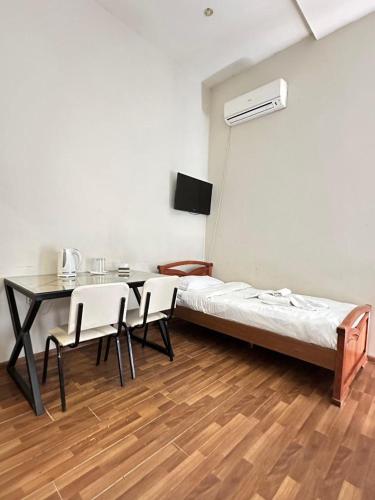 a room with a bed and a table and chairs at NEW BELLA HOTEL in Yerevan